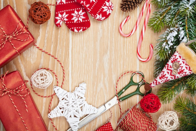 Envoltura de regalos de Navidad y abeto de nieve sobre fondo de mesa de madera