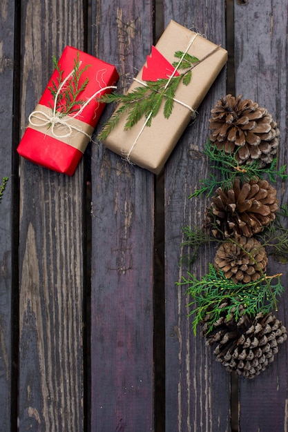 Envoltura de regalos orgánicos de Navidad con pinos de cono y almuerzos sobre fondo de madera