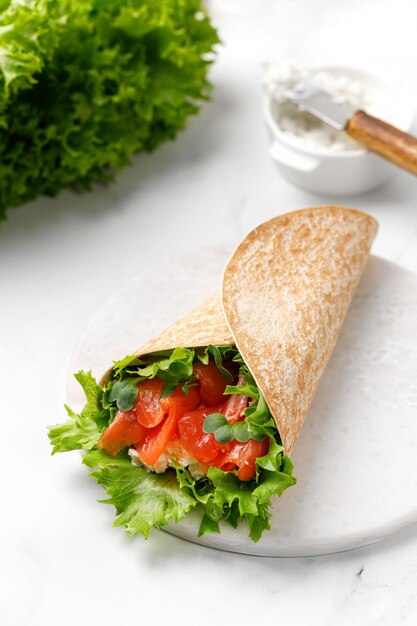 Envoltura de sándwich con salmón y hojas de lechuga Envolturas de tortilla con salmón y microvegetales