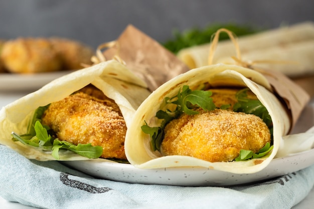 Envolturas de tortilla con chuletas de pollo o pavo, rúcula y salsa de crema agria.