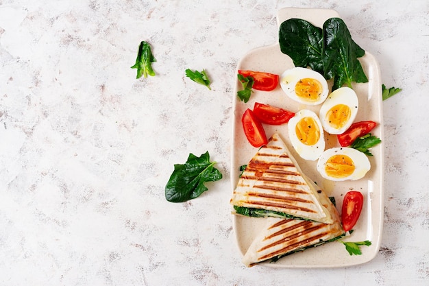 Envolturas de tortilla fresca con espinacas y queso sobre fondo claro Concepto de comida saludable Comida vegetariana Vista superior arriba