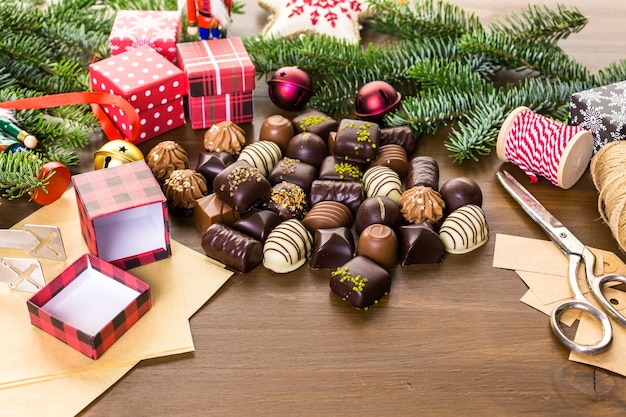 Envolver bombones surtidos en pequeñas cajas para regalos de Navidad.