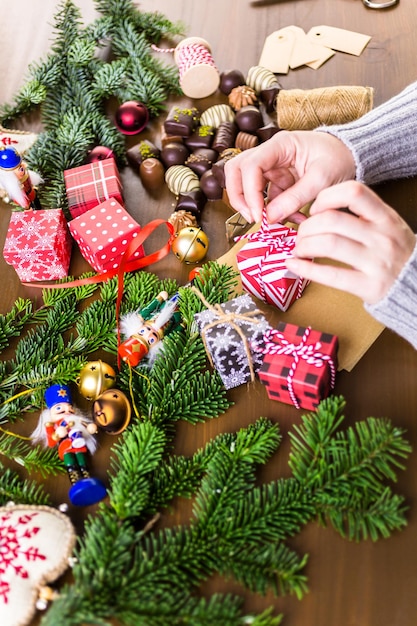 Envolver bombones surtidos en pequeñas cajas para regalos de Navidad.