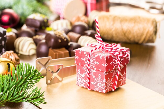 Envolver bombones surtidos en pequeñas cajas para regalos de Navidad.