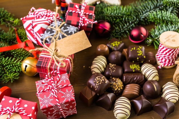 Envolver bombones surtidos en pequeñas cajas para regalos de Navidad.