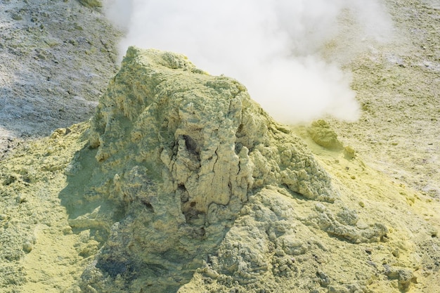 Enxofre cristalizado em torno de um solfatara fumegante na encosta de um vulcão