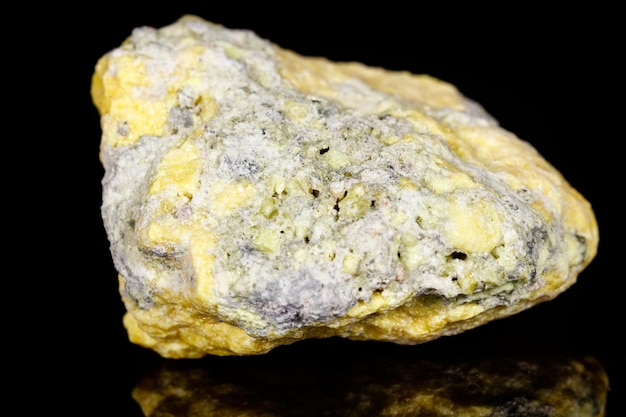 Enxofre de pedra mineral macro no fundo preto
