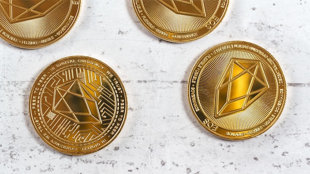 EOS comemorativa dourada - criptomoeda EOSIO - moedas na placa de pedra branca, foto aérea