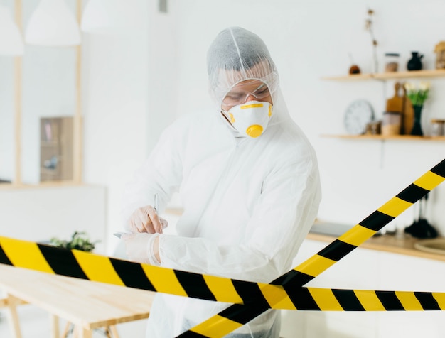 epidemiologista em roupas de proteção em área restrita