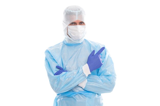 Epidemiologista médico homem vestindo máscara respiratória e roupa protetora de segurança apontando o dedo em luvas em fundo branco isolado, cópia espaço, cobiçado 19 sars.