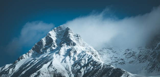 Epischer schneebedeckter Berggipfel mit Wolken in der Winterlandschaft Alpen Österreich