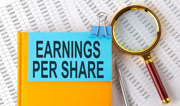EPS Earnings Per Share texto no adesivo no notebook com lupa e gráfico Conceito de negócios