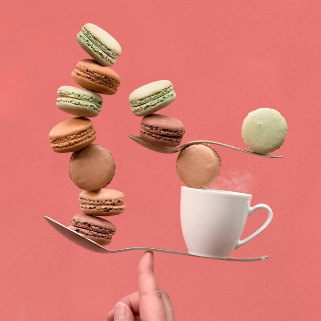 Equilibrar una taza de café y macaronos en un dedo