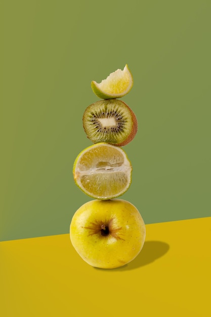 Equilibrio de frutas verdes manzana limón lima kiwi con sombra