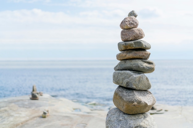 Equilibrio de rocas apiladas, apiladas con precisión. torre de piedra en la orilla. copia espacio