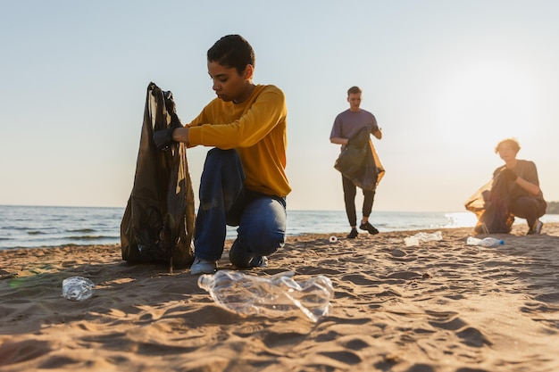 Equipa de ativistas voluntários do Dia da Terra recolhe lixo, limpa a zona costeira da praia