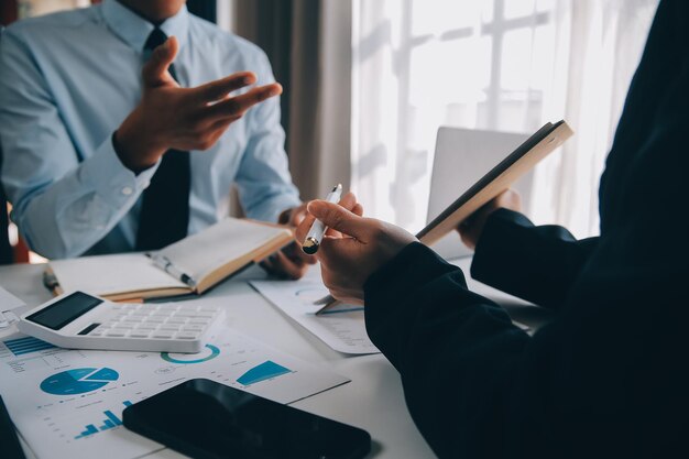 Equipa de negócios trabalhando com um novo plano de projeto de startup e discussão de informações para estratégia financeira com laptop e tablet digital em uma sala de negócios moderna