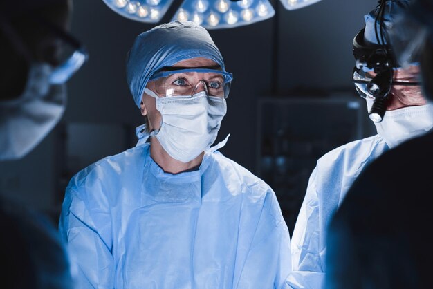 Foto equipa médica fazendo uma operação cirúrgica em uma sala de cirurgia moderna