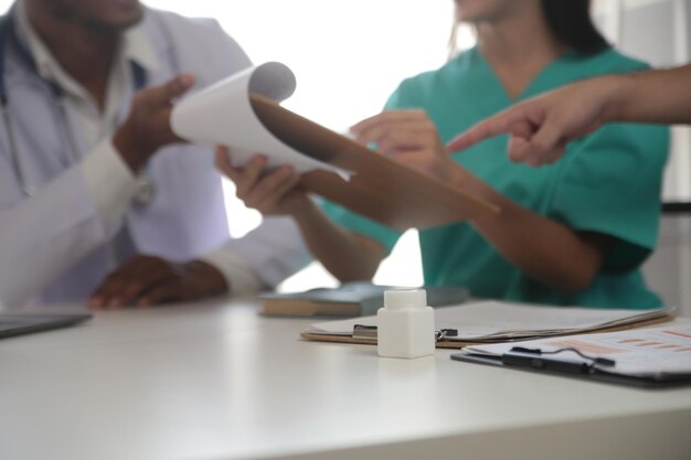 Foto equipa médica reunida em torno de uma mesa num hospital moderno