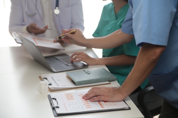 Foto equipa médica reunida em torno de uma mesa num hospital moderno