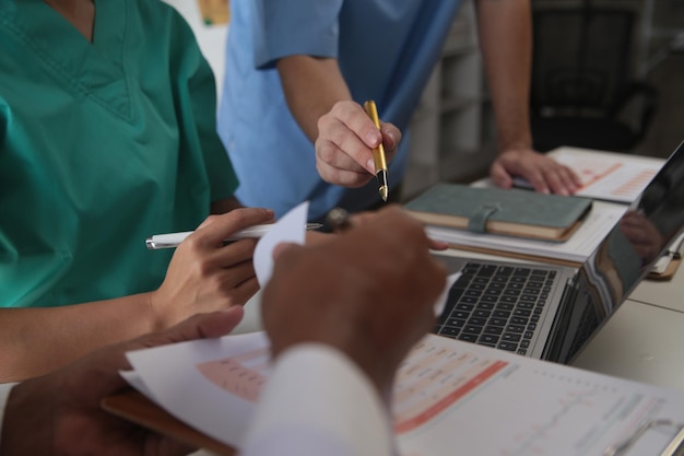 Foto equipa médica reunida em torno de uma mesa num hospital moderno