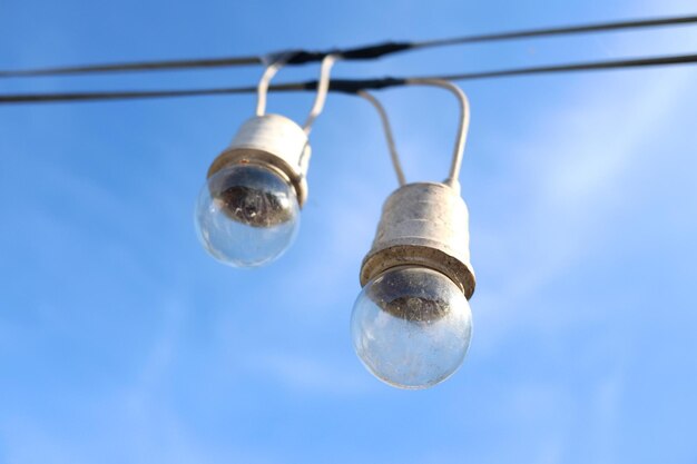 Equipado y eléctrico con bombillas está colgando en el viento y la luz del sol en el cielo azul