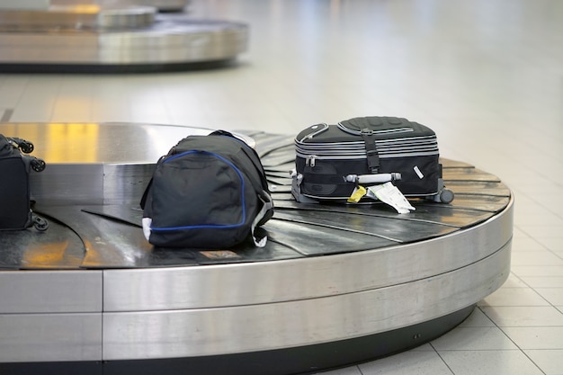 Foto equipaje en cinta transportadora en el aeropuerto. área de reclamo de equipaje en el aeropuerto, línea de equipaje abstracta con muchas maletas.