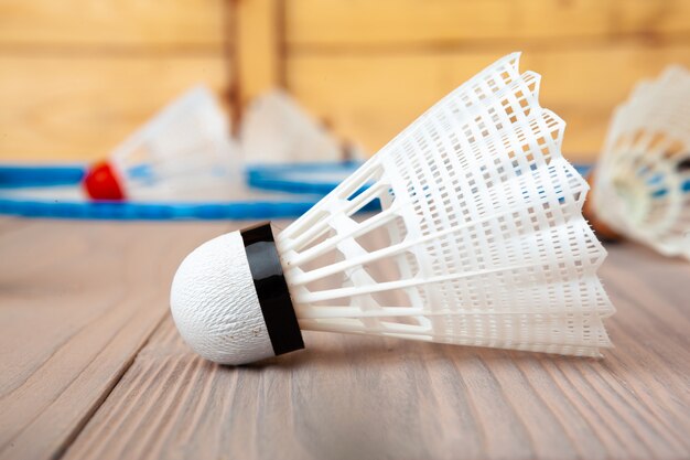 Equipamento de badminton. Raquetes e peteca na mesa de madeira