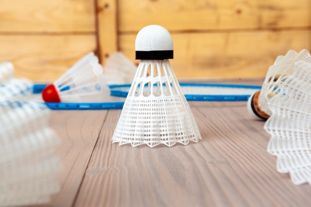 Equipamento de badminton. Raquetes e peteca na mesa de madeira