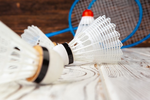 Equipamento de badminton. Raquetes e peteca na mesa de madeira