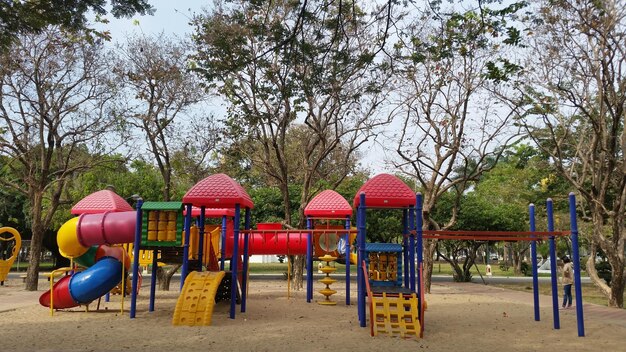 Foto equipamento de brincadeira ao ar livre no parque contra árvores no parque