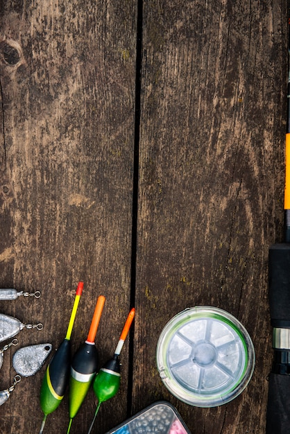 equipamento de pesca em uma mesa de madeira. Bóias, chumbadas, linha de pesca, ganchos em um fundo de madeira