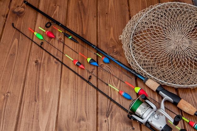 Equipamento de pesca - flutuador de pesca com vara de pescar e iscas em uma bela madeira azul