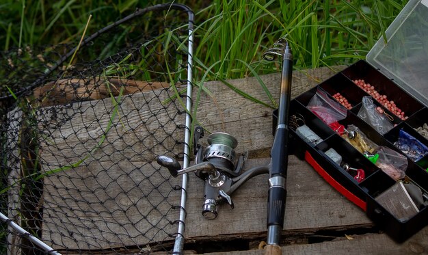 Equipamento de pesca na margem do rio, vara de isca, vara de fiar, peixe. Natureza. Foco seletivo