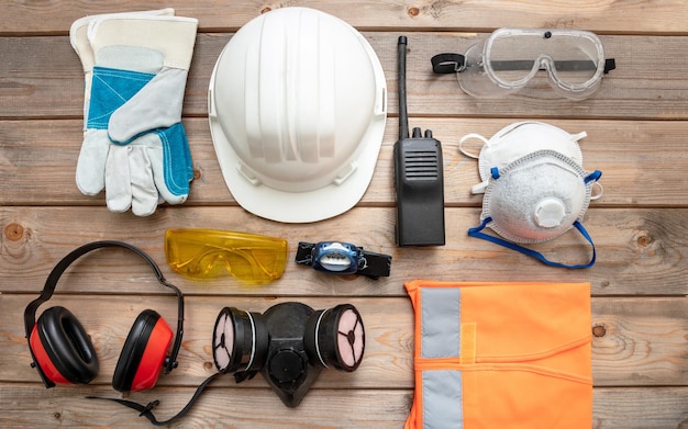 Equipamento de proteção de segurança do trabalho deitado sobre fundo de madeira