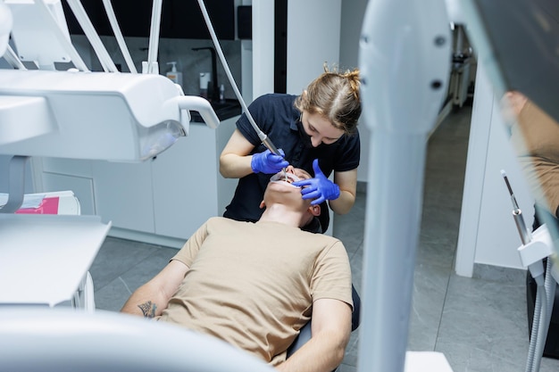 Equipamento dentário moderno O ortodontista instala o sistema de suporte nos dentes dos pacientes Tratamento dentário Cadeira dentária