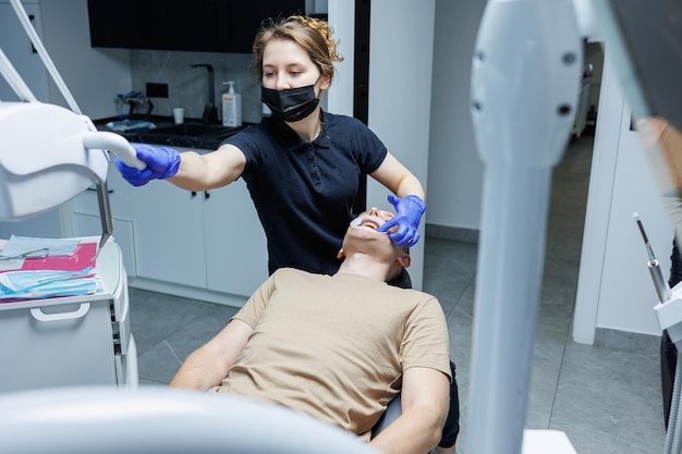 Equipamento dentário moderno O ortodontista instala o sistema de suporte nos dentes dos pacientes Tratamento dentário Cadeira dentária