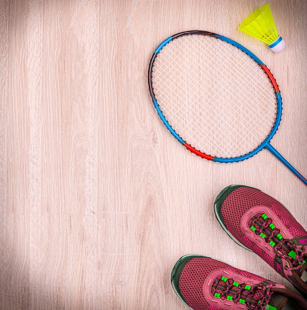 Equipamento desportivo com raquetes de badminton e tênis com fundo de madeira