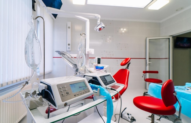 Foto equipamento médico de medicina odontológica e interior do conceito de estomatologia do novo escritório de clínica odontológica moderna com cadeira