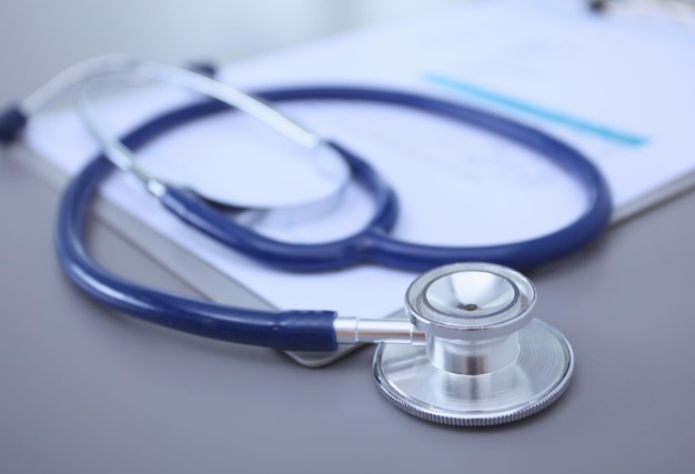 Equipamento médico estetoscópio azul e tablet em fundo branco Equipamento médico