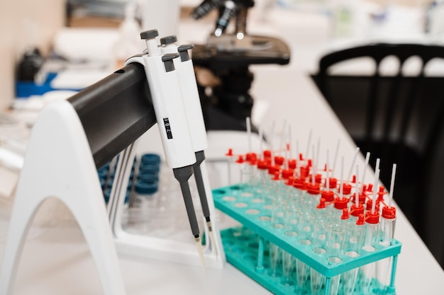 Foto equipamento médico para análise e análise de sangue usando micro dosador de microscópio e tubos e frascos médicos