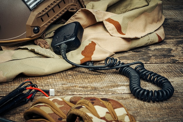 Equipamento militar, walkie-talkie com uniforme militar na placa de madeira