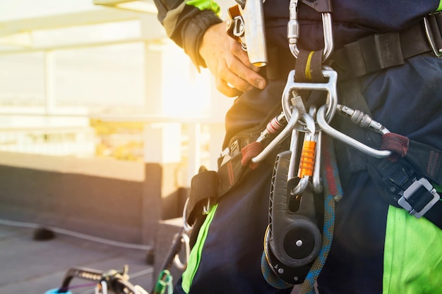 Equipamentos de escalada antes de iniciar o trabalho Equipamento de alpinista industrial no telhado do edifício durante o trabalho de arranha-céus da indústria