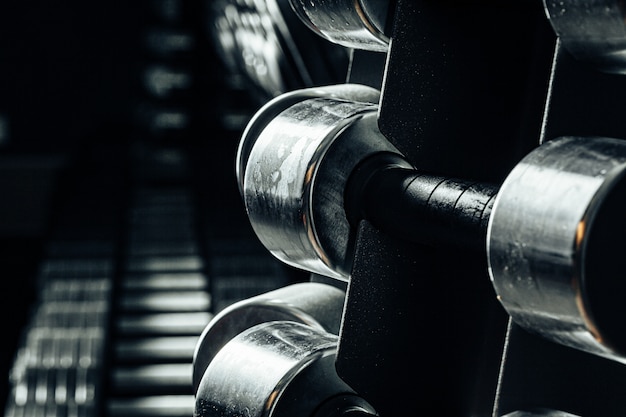 Equipamiento deportivo en gimnasio. Cerrar pesas de diferente peso