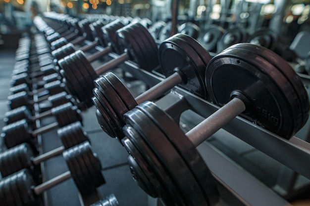 Equipamiento deportivo en un gimnasio moderno con pesas de diferentes pesos en el estante