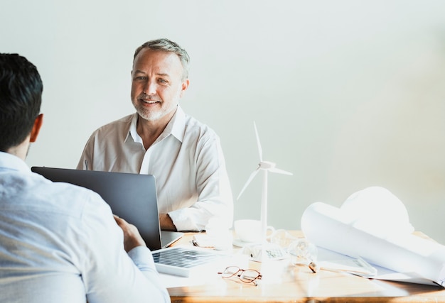 Equipe alegre de engenheiros ecológicos em uma reunião