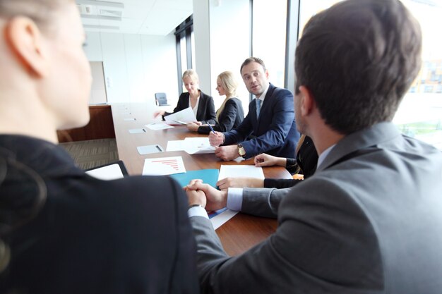 Equipe analítica de negócios trabalhando em reunião com documentos financeiros