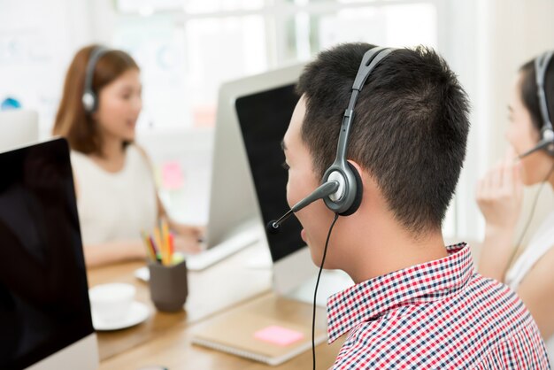 Equipe asiática de agentes de atendimento ao cliente de telemarketing,