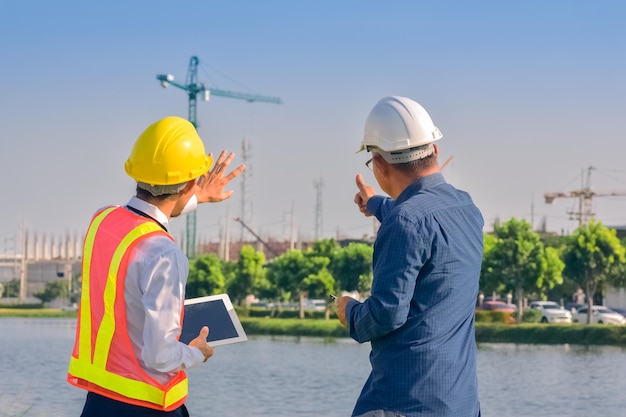 Equipe asiática Engenheiros de construção supervisionando o progresso do projeto de construção na nova fábrica Consultoria de engenharia Pessoas no canteiro de obras Inspetor de construção