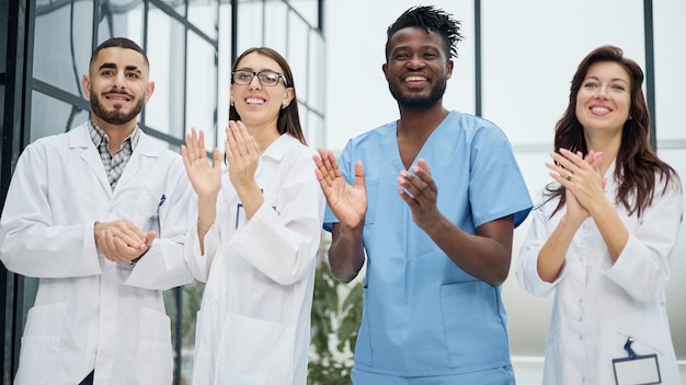 Equipe bem sucedida de diferentes médicos batendo palmas